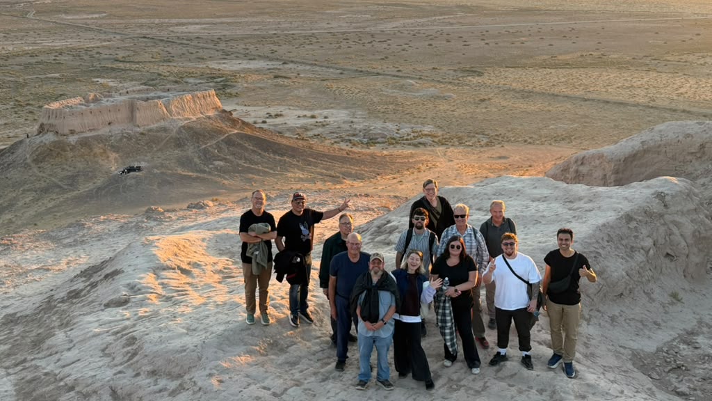 A group of travellers together on a sunlit ridge overlooking Ayaz Kala